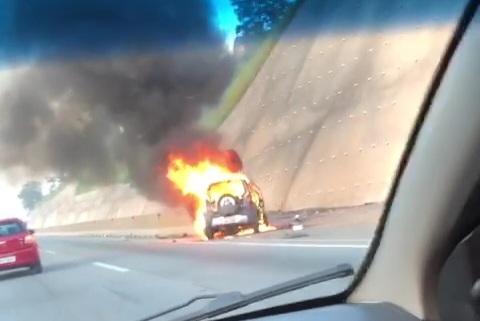 Carro pega fogo após se chocar em barreira de concreto
