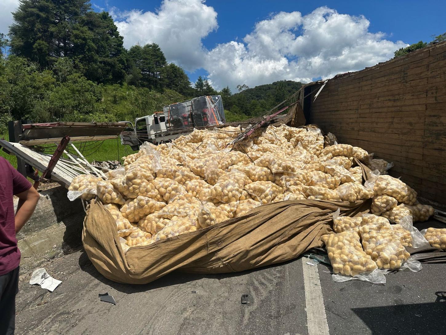 Caminhão tomba após colisão e espalha carga na Régis Bittencourt