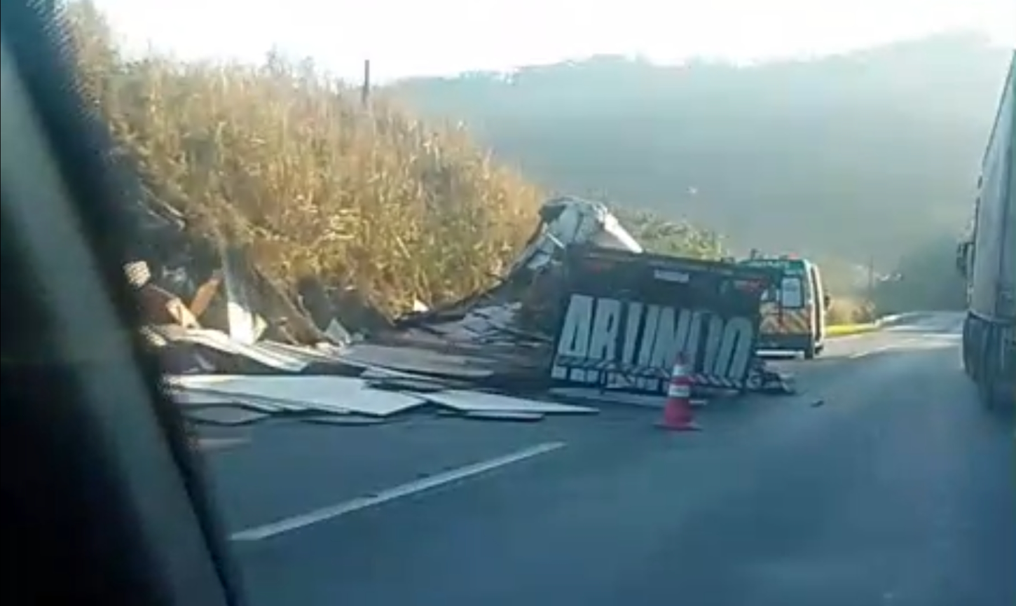 Carreta tomba e derrama carga de madeira em rodovia federal de Cajati/SP